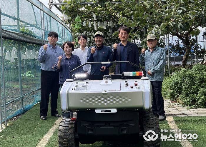 김운학 산업지원본부장(오른쪽 두번째)이 관내 농가에 운반로봇을 보급하고 기념촬영을 하고 있다.