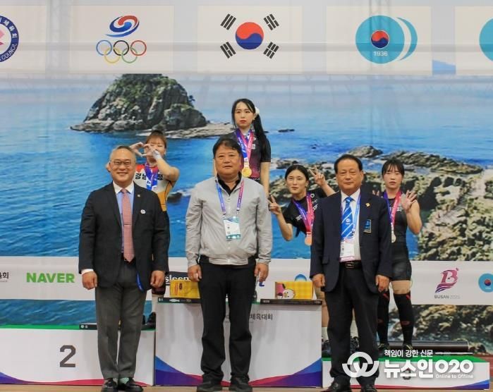 수상대에서 금메달을 걸고 선수들과 기념사진 찍는 신재경 선수(수상대 왼쪽 2번째)