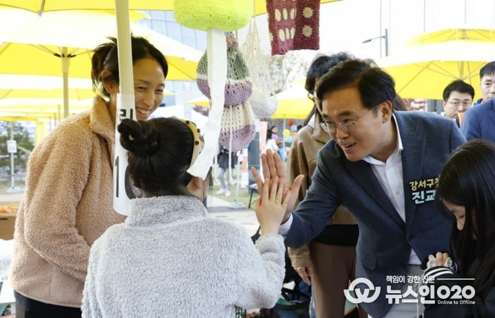 진교훈 서울 강서구청장(오른쪽)이 25일 발산근린공원에서 열린 ‘발산마을축제’에서 플리마켓에 참여한 아이와 손을 맞대고 있다.