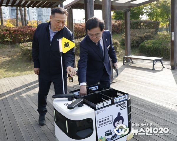 진교훈 서울 강서구청장(오른쪽)이 마곡하늬공원에서 열린 ‘AI 기반 자율주행 로봇서비스 실증 시연회’에서 빈 캔을 수거함에 넣고 있다.