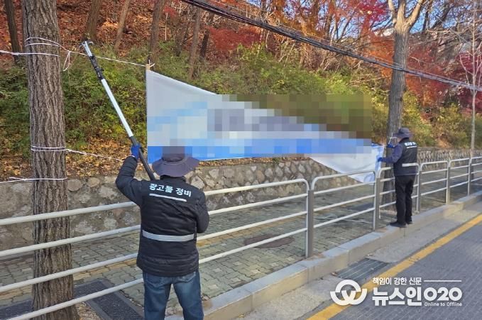 강북구 점검반이 불법 현수막을 정비하고 있다.