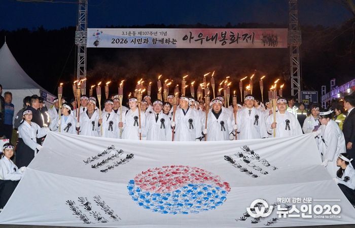 1. 28일 천안아우내장터에서 열린 ‘2026 아우내봉화제’에서 시민들이 대형태극기와 함께 횃불을 들고 행진하고 있다.
