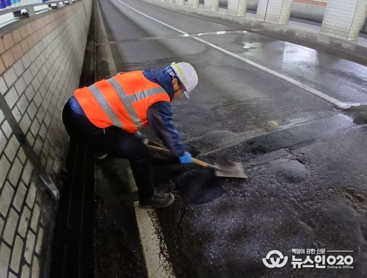 천안시 도로보수원들이 겨울철 폭설과 염화칼슘 영향으로 훼손된 도로 포트홀 구간에 아스콘을 충진하며 긴급 복구 작업을 진행하고 있다